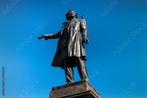 monument to Pushkin in St. Petersburg with a pigeon on a shoulder