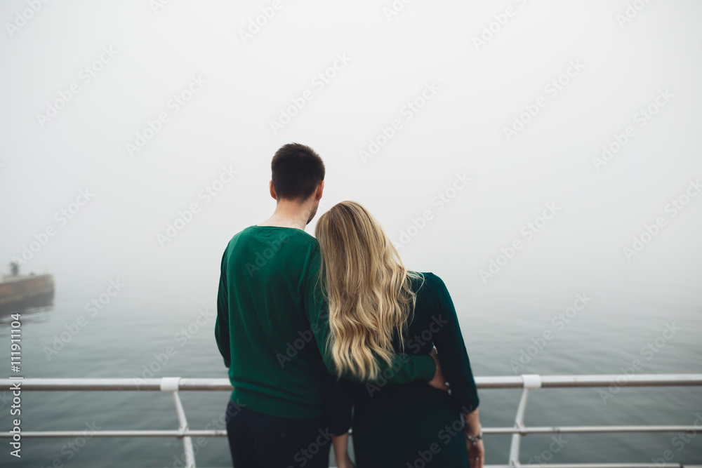 Happy couple on the pier, young family in love spending honeymoon vacation luxury islands Happy couple on the pier, young family in love spending honeymoon vacation luxury islands