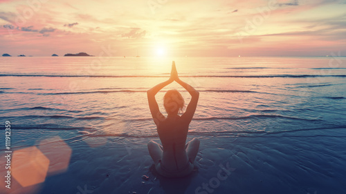 Photography Silhouette young woman practicing yoga on the sunset beach