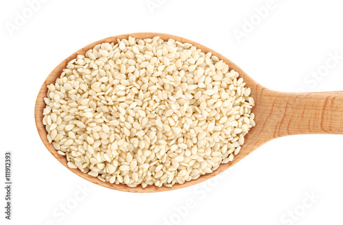 Wooden spoon with sesame seeds isolated on white background.