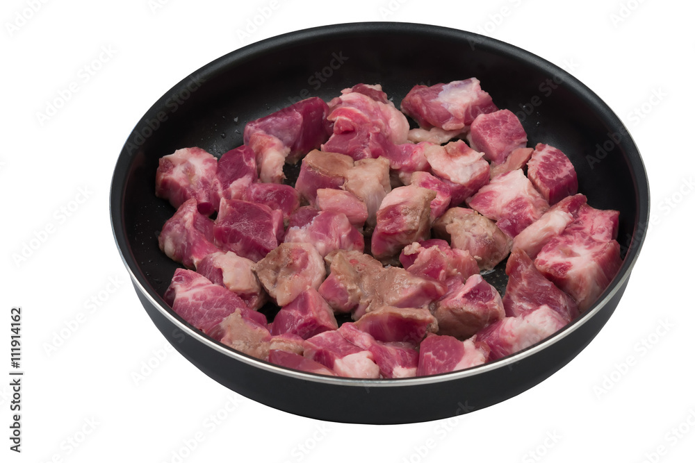 Fried pieces of raw meat in a frying pan