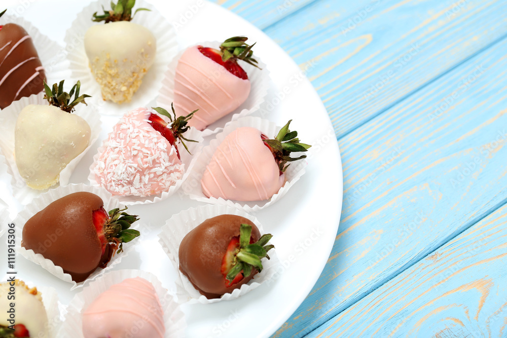 Strawberries covered in chocolate on a blue wooden table Strawberries covered in chocolate on a blue wooden table