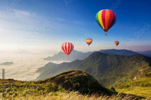 Foto Colourful hot-air balloons flying over the mountain
