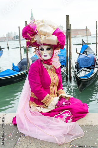 Pink dressed woman and gondolas at Venice carnival