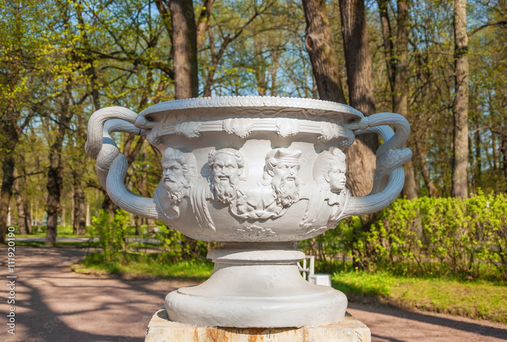 Garden sculpture in the form of an ancient vase with masks
