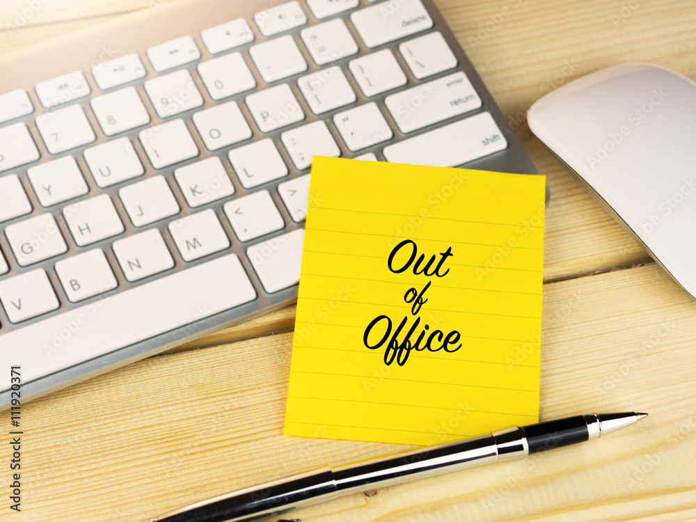 Out of office on sticky note on work desk Out of office on sticky note on work desk