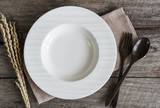 Empty dish with spoon and fork on old wooden background