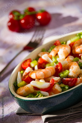 Salad of shrimps inside an oval bowl