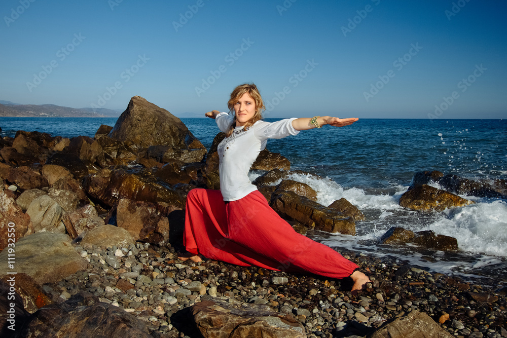 Girl doing yoga. Ocean in background