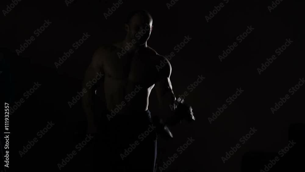 Hot professional bodybuilder doing dumbbell curls, boasting of masculine power Hot professional bodybuilder doing dumbbell curls, boasting of masculine power