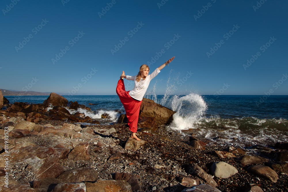 Girl doing yoga. Ocean in background Girl doing yoga. Ocean in background
