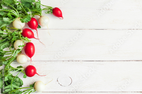 white and red radishes on a white wooden background, flat lay, top view