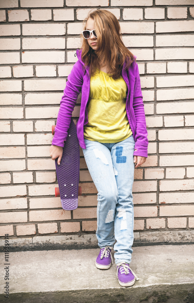 Girl in colorful clothes with a skateboard