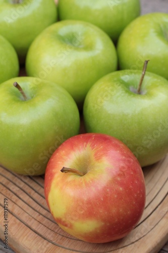 green and red apples on wood background.