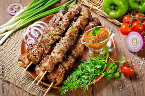 Fotografi Grilled beef liver kebabs on a dark wooden background