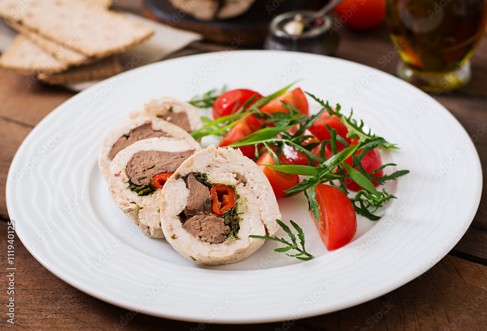 Diet baked chicken rolls stuffed liver, chili and herbs with a salad of tomatoes and arugula. Dietary menu. Proper nutrition.