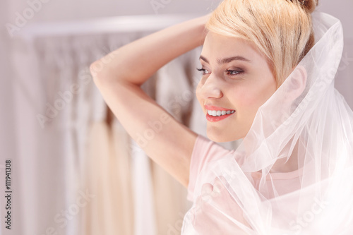 Pretty young woman trying on wedding clothing
