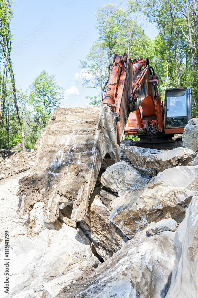 Fototapeta premium Excavator with big shovel to work with rocks