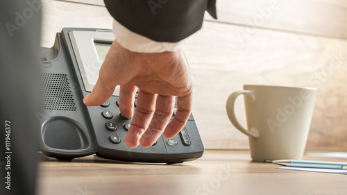 Fotografia Low angle view of a businessman hand dialing telephone number on