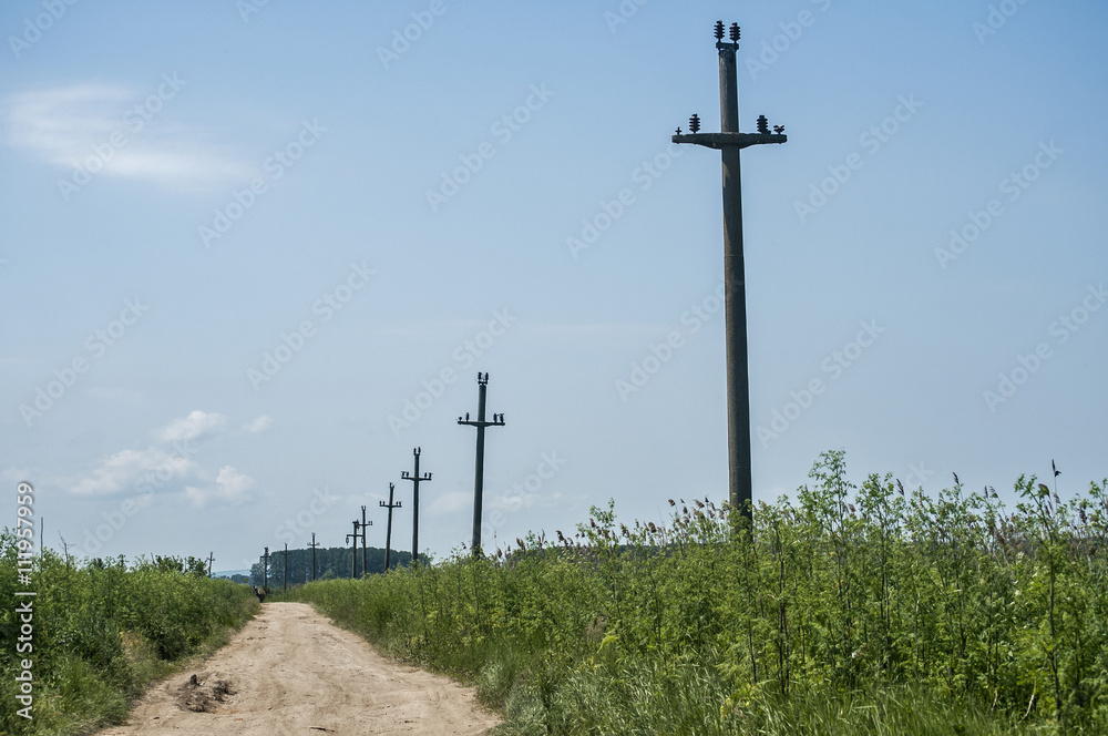 Countryside landscape with dirt road and abandoned power poles Countryside landscape with dirt road and abandoned power poles
