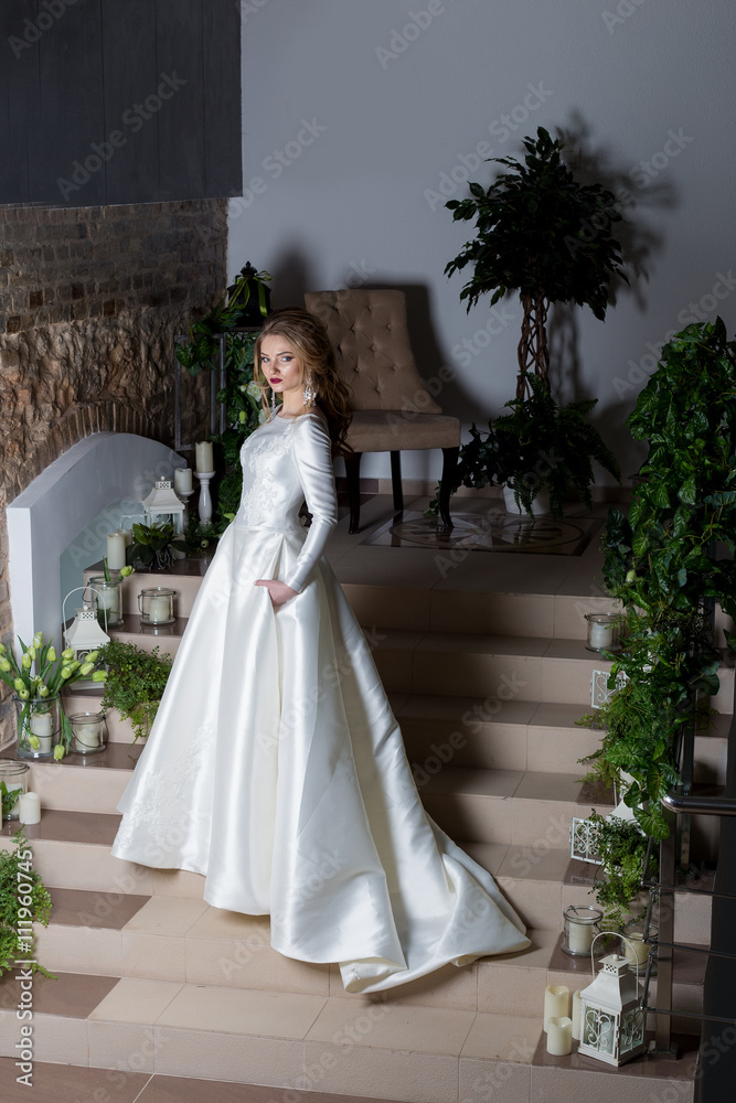 beautiful sweet girl elegant bride in an elegant wedding platestoit on the stairs