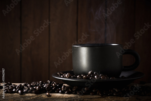 Coffee cup and coffee beans on a wood background.