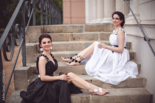 Two girls in black and white sitting on the steps photo