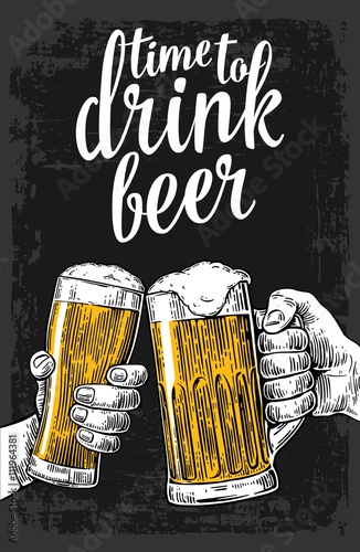 Two hands holding and clinking with two beer glasses mug