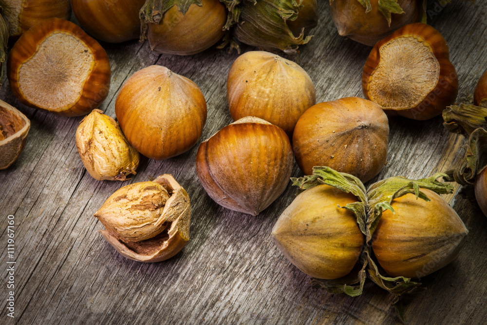 Whole and chopped hazelnuts on wooden table Whole and chopped hazelnuts on wooden table