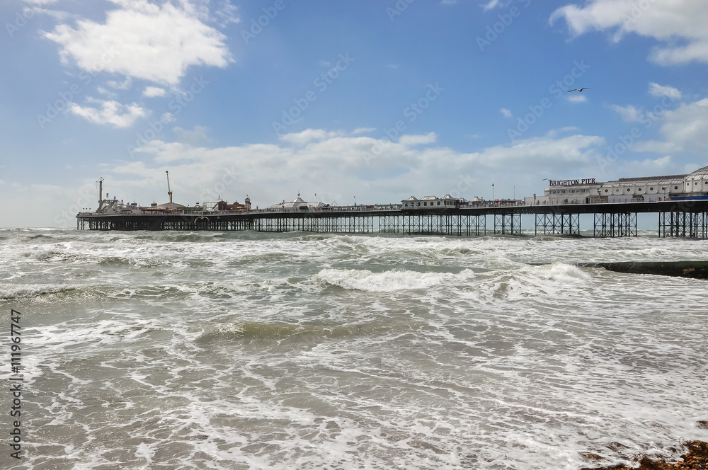 View of rough sea and Brighton pier in UK