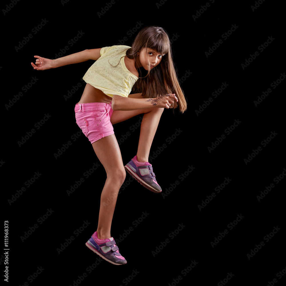 Young girl dancing against black