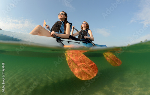 young women smiling while kayaking in ocean