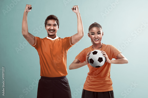 Fototapeta Naklejka Na Ścianę i Meble -  Happy couple football fan holding ball