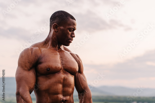 Portrait of handsome black african american athlete on the sunrise sky background photo