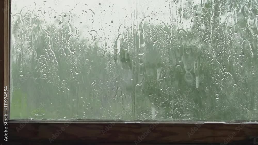 SLOW: A big raindrops falls behind a window