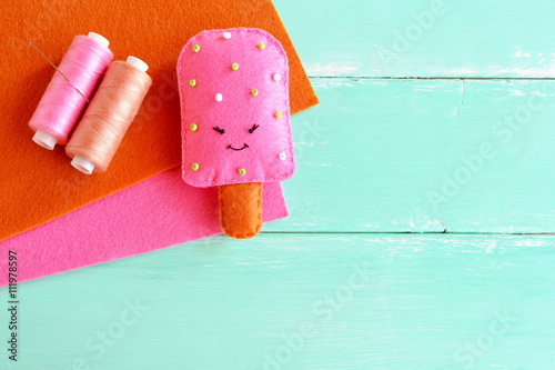 Adorable felt ice cream toy. Felt play food pattern. DIY felt food. Easy fabric crafts for kids. Thread, brown and pink wool sheets. Summer fun background. 