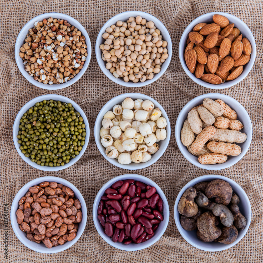 Mixed beans , lentils and nuts in the white bowl on brown cloth Mixed beans , lentils and nuts in the white bowl on brown cloth