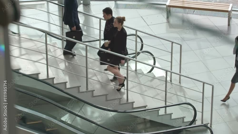 Business people walking up and down stairs in modern office building, slow motion shot on Sony NEX 700 Business people walking up and down stairs in modern office building, slow motion shot on Sony NEX 700