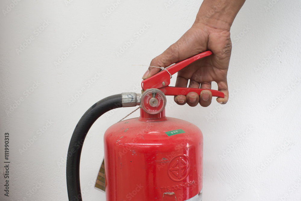 white hand presses the trigger fire extinguisher