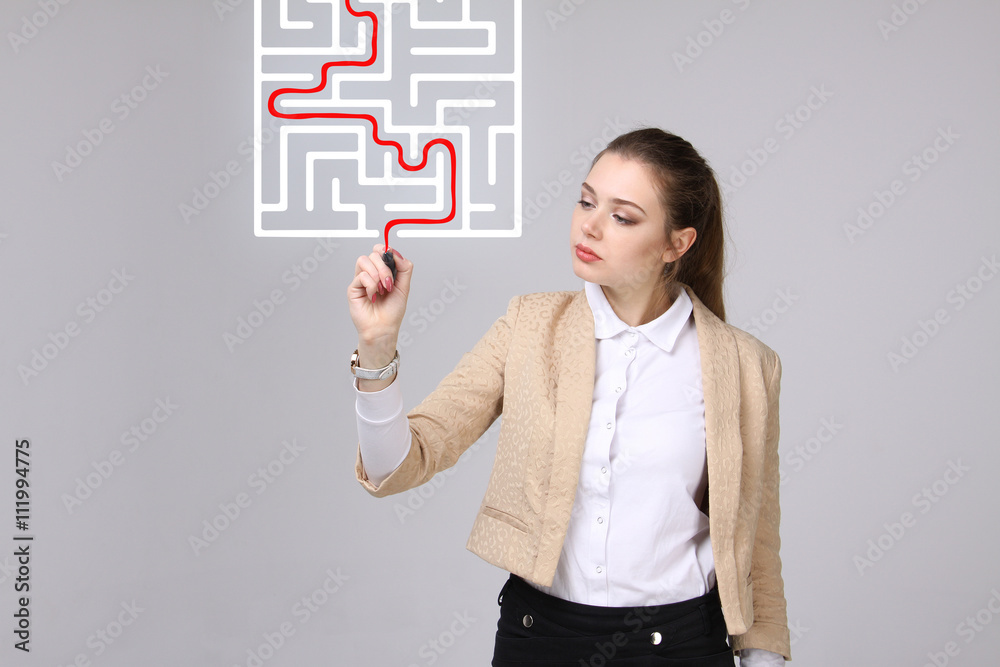 Young woman finding the maze solution, writing on whiteboard. Young woman finding the maze solution, writing on whiteboard.