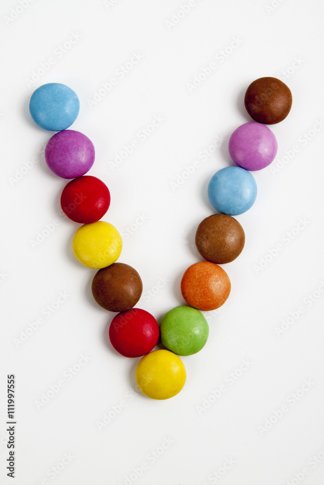 La lettera V formata da coloratissimi confetti di cioccolato.