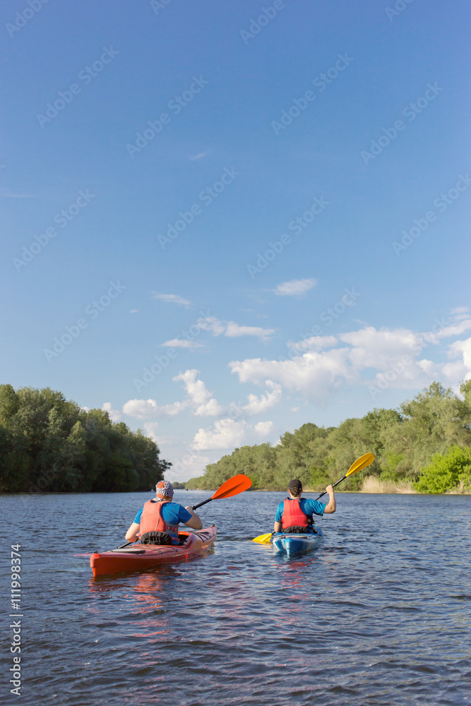 Man traveling on the river in a kayak in the summer.