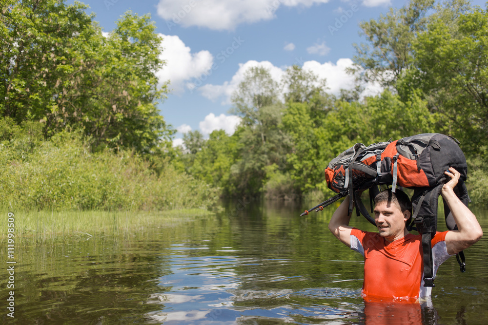 Man crossing the river with a backpack. Man crossing the river with a backpack.