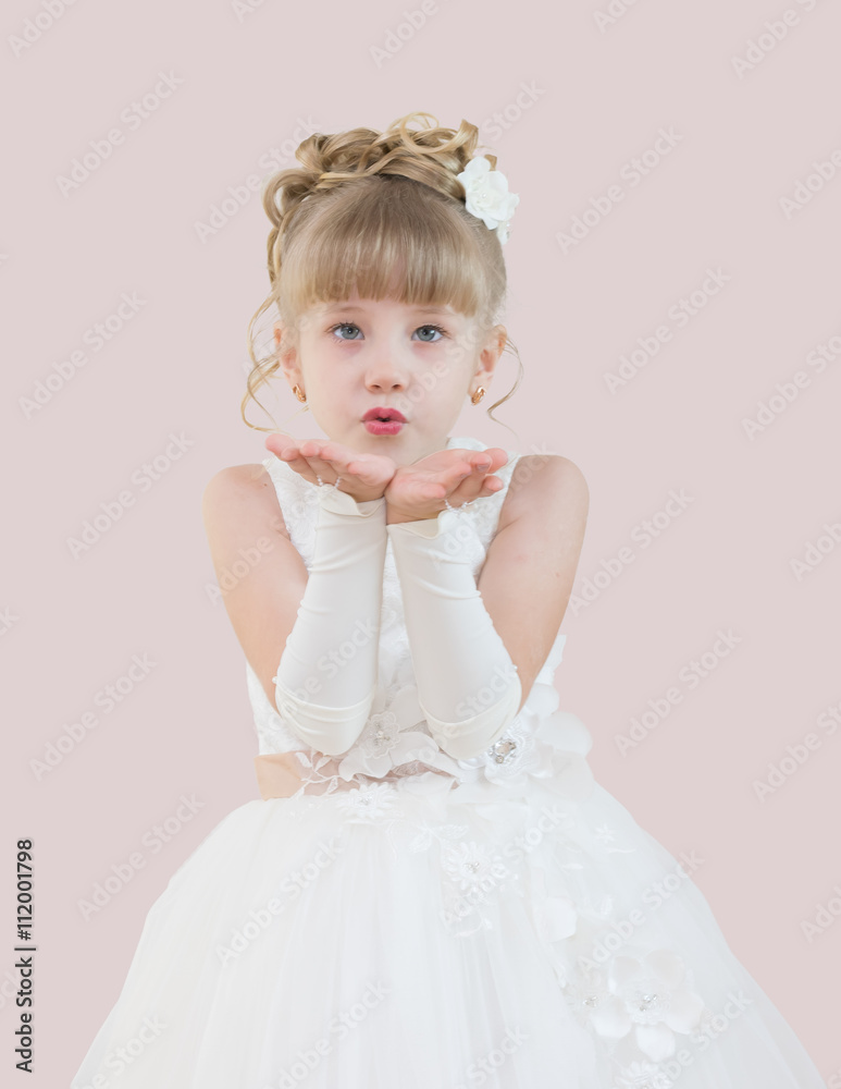 little girl in a ball gown isolated on a pink background