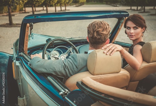 Wealthy couple in a classic convertible