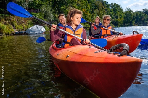 Happy best friends having fun on a kayaks