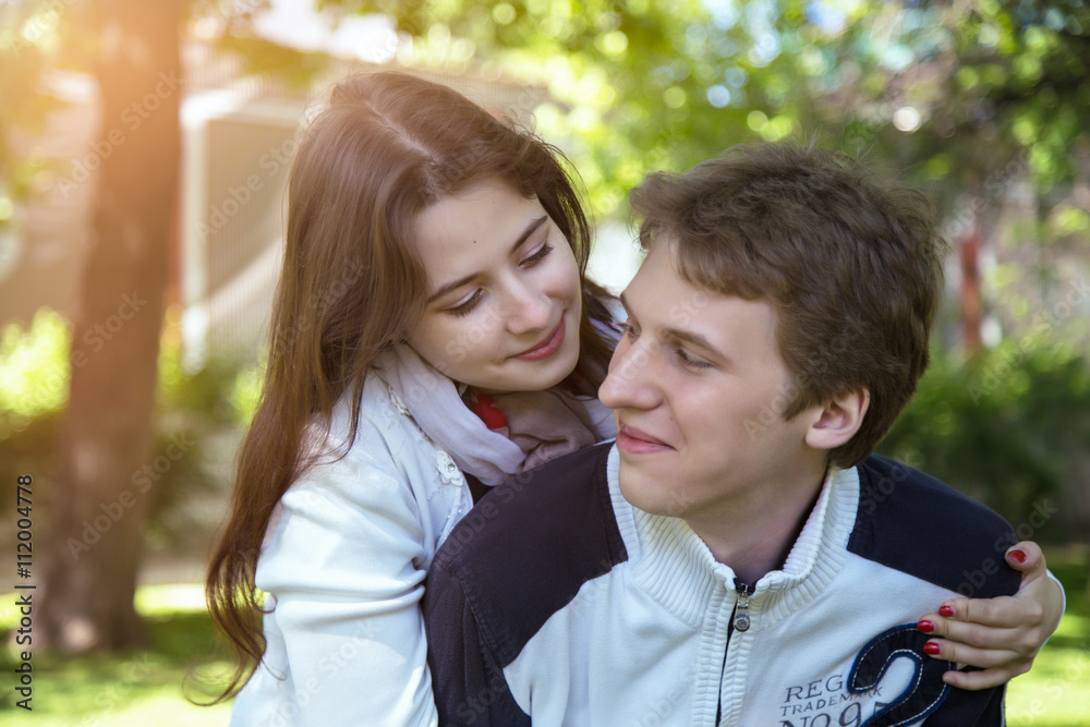 Fototapeta premium Side view of couple standing on forest trail and hugging