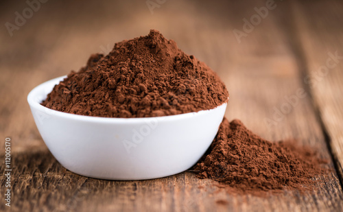 Cocoa powder on wooden background
