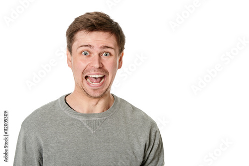 Happy young man with manic expression, on gray background © Terence Mendoza