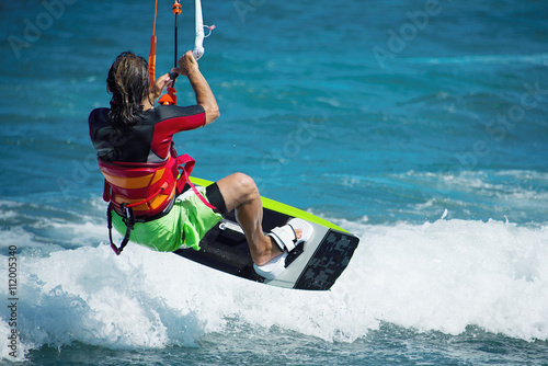 kitesurfer flying over the wave.Kitesurfing in blue sea
